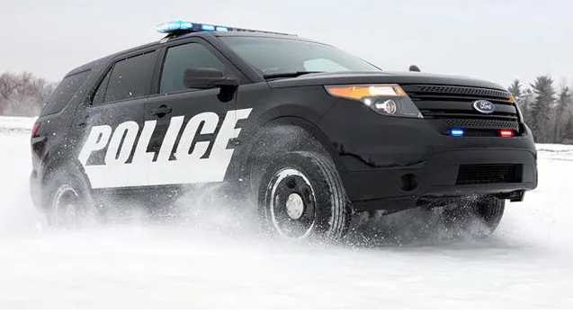 Police car patrolling snowy roads to enforce snow laws