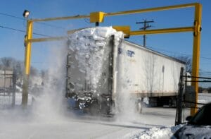 Truck Snow Scraper System collecting snow in next vehicles path,